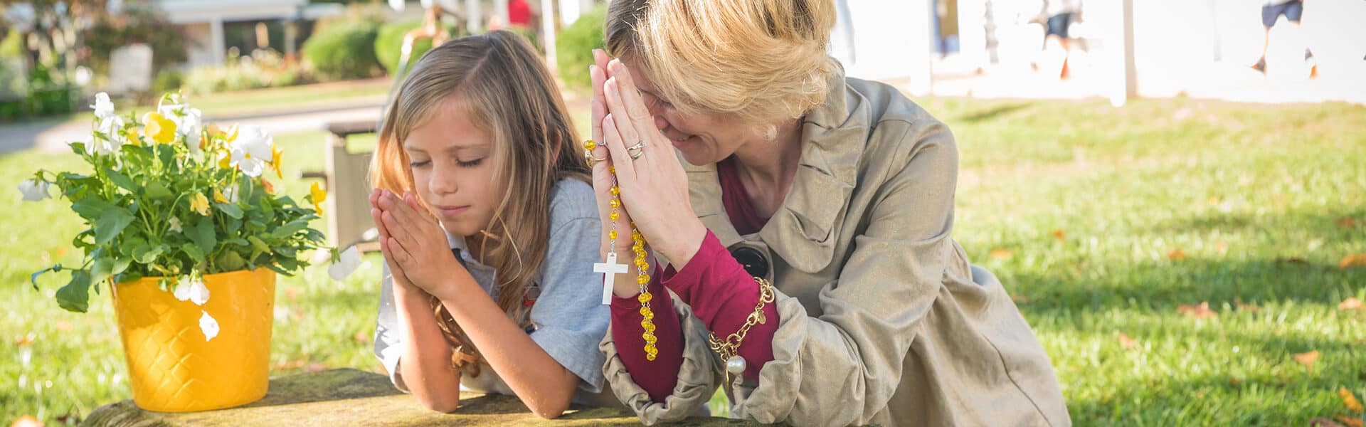 Student and teacher praying the Rosary together