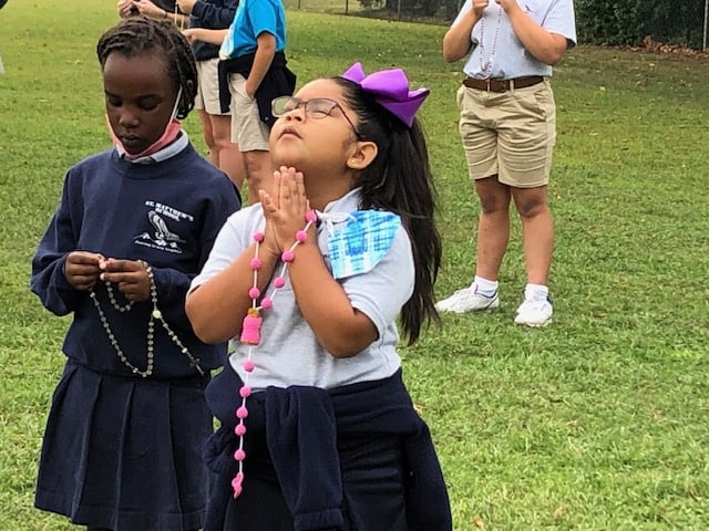 Students praying the Rosary outside
