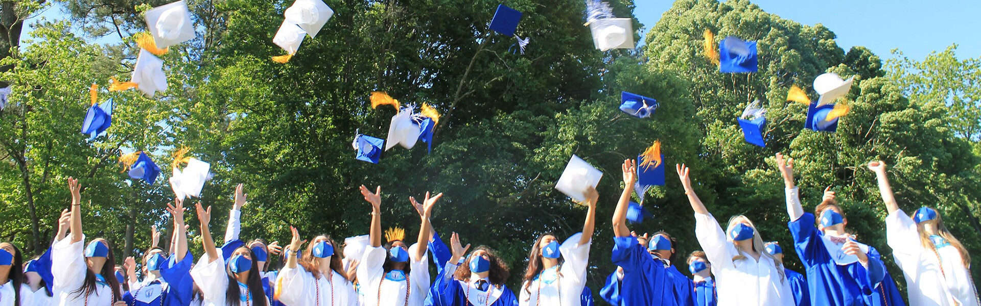 High school graduates throwing caps in the air at graduation